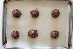 Chocolate oatmeal cookies scooped onto a baking sheet.