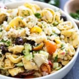 Bowl of Greek Tortellini Pasta Salad with vegetables, feta cheese, and parsley.