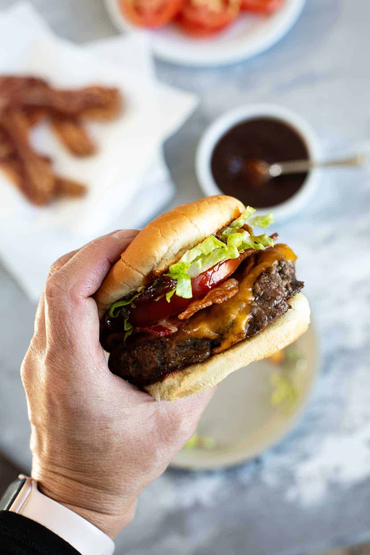 Hand holding a Chipotle Honey BBQ Burger.