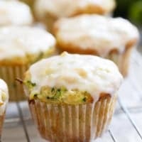 Coconut Lime Zucchini Muffins topped with a coconut lime glaze on a cooling rack.
