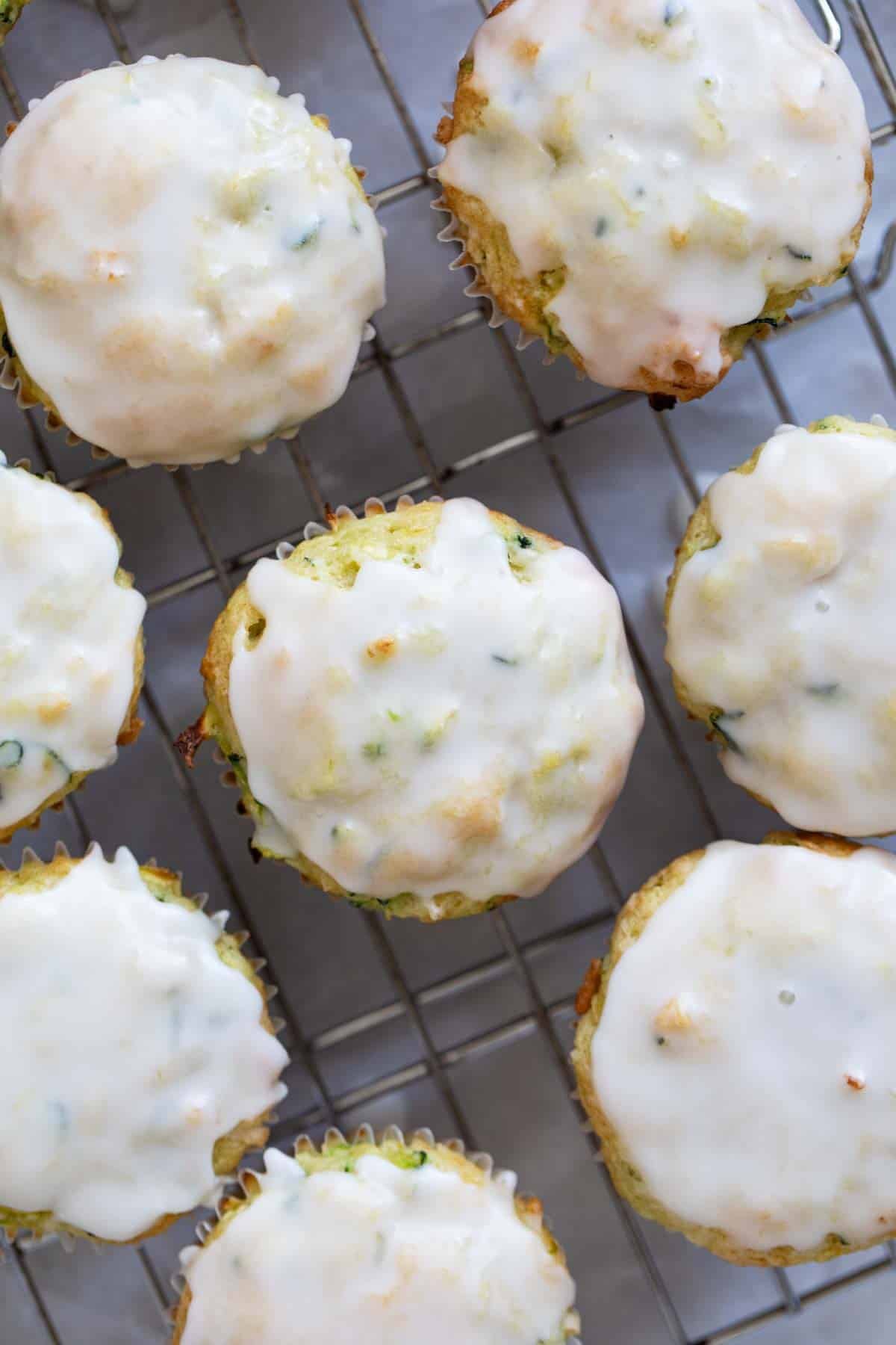 Coconut Lime Zucchini Muffins topped with glaze on a cooling rack.