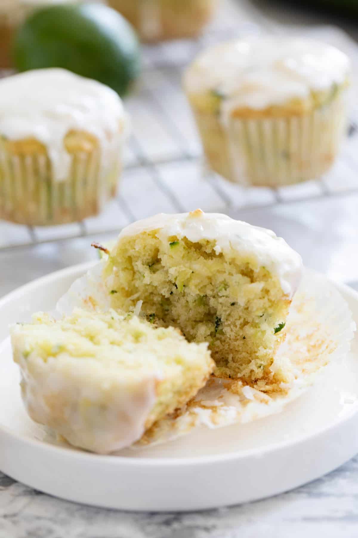 Coconut Lime Zucchini Muffin cut in half on a small plate.