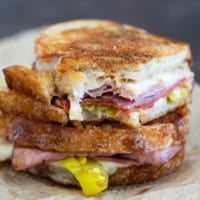 Italian Grilled Cheese sandwich cut in half and stacked, with a bite taken from one half.