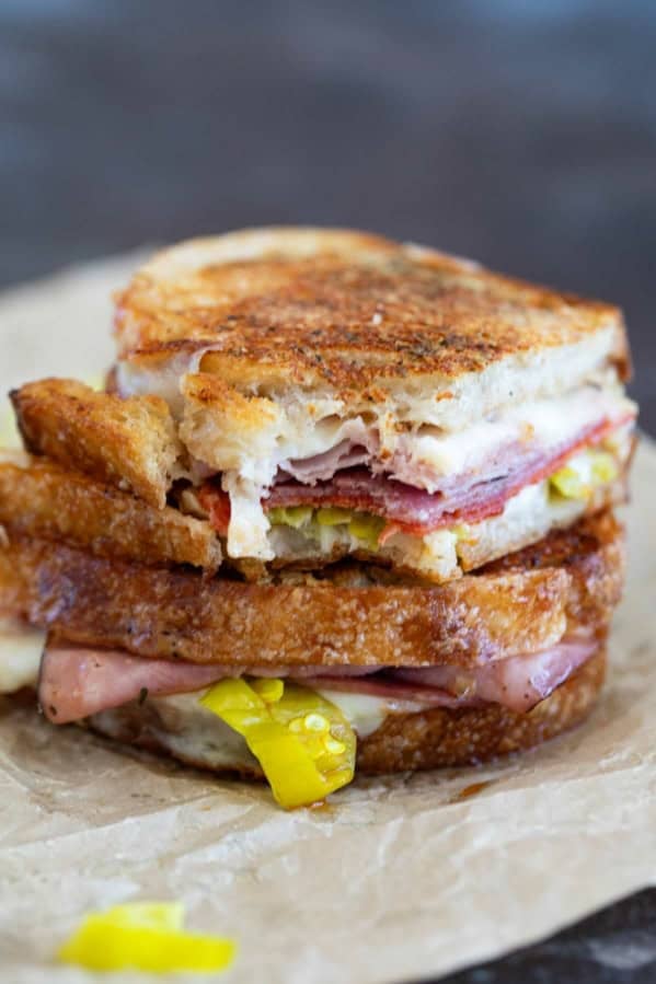 Italian Grilled Cheese sandwich cut in half and stacked, with a bite taken from one half.