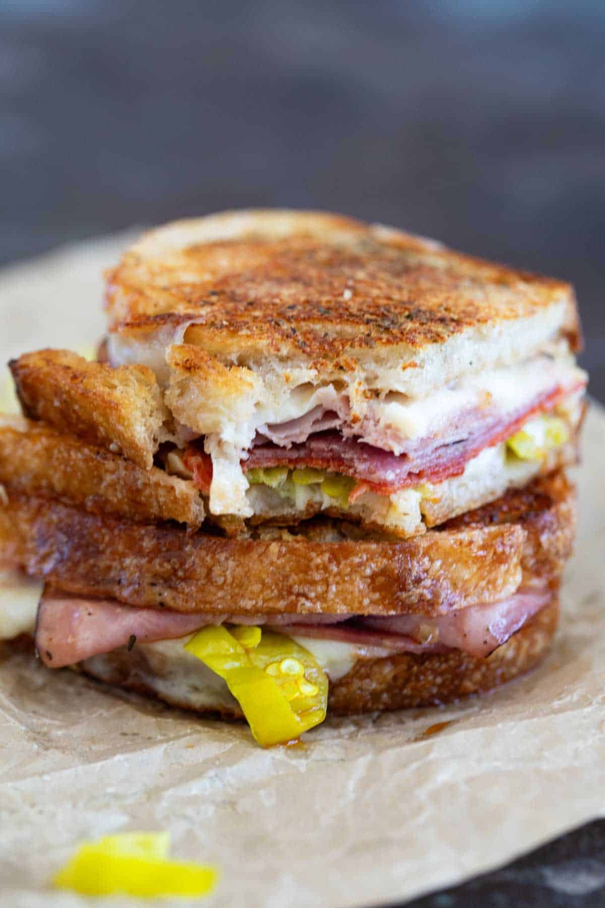 Italian Grilled Cheese sandwich cut in half and stacked, with a bite taken from one half.