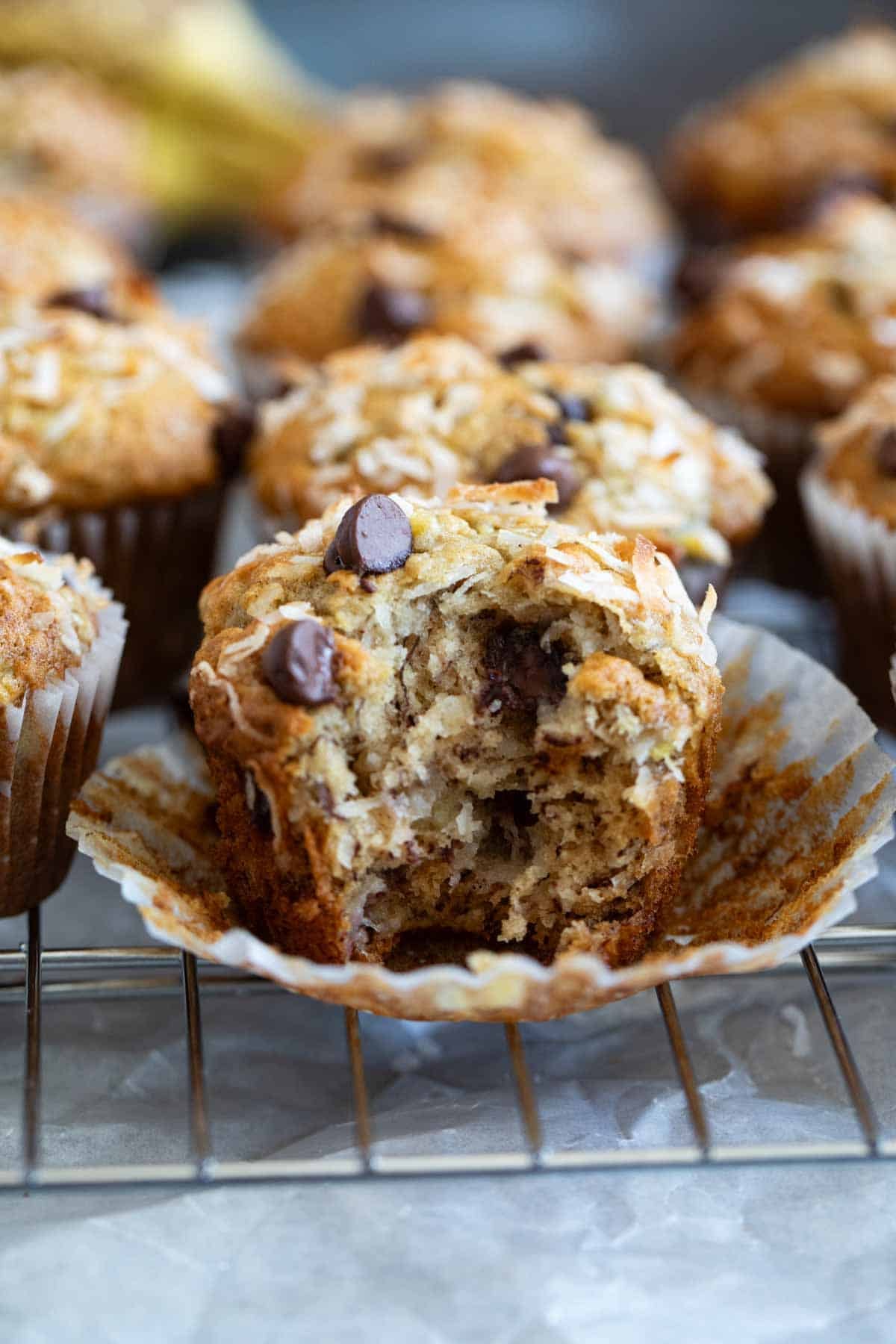 Banana Chocolate Chip Muffins with Coconut with a bite taken from one muffin.
