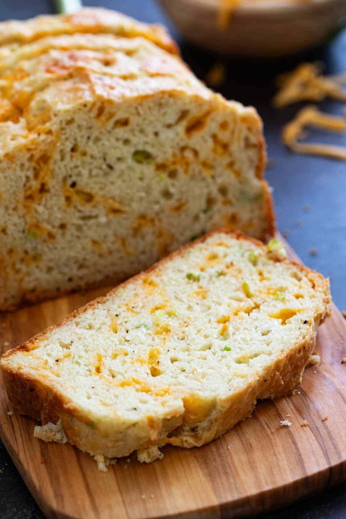 Slice of Cheddar Black Pepper Quick Bread on a cutting board.