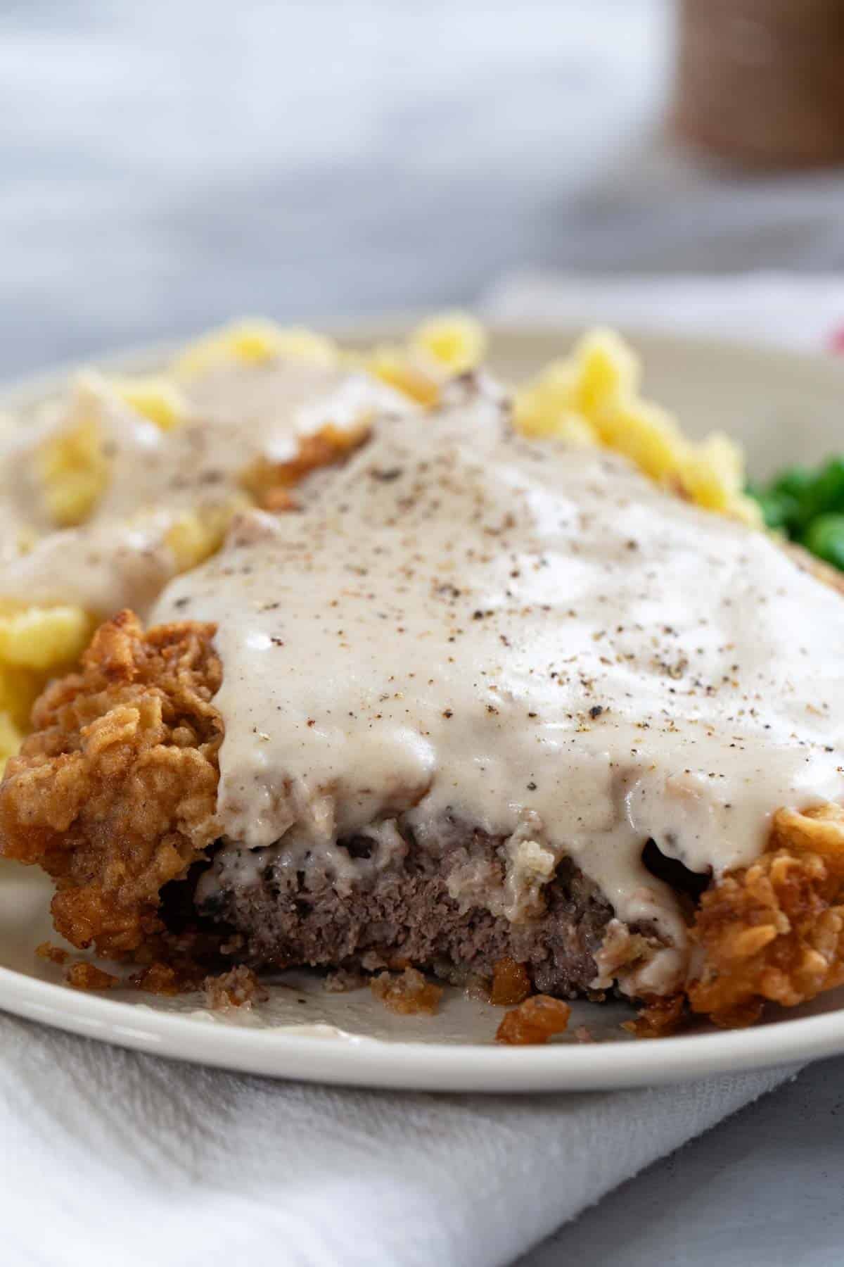Chicken Fried Steak with a bite taken from it.
