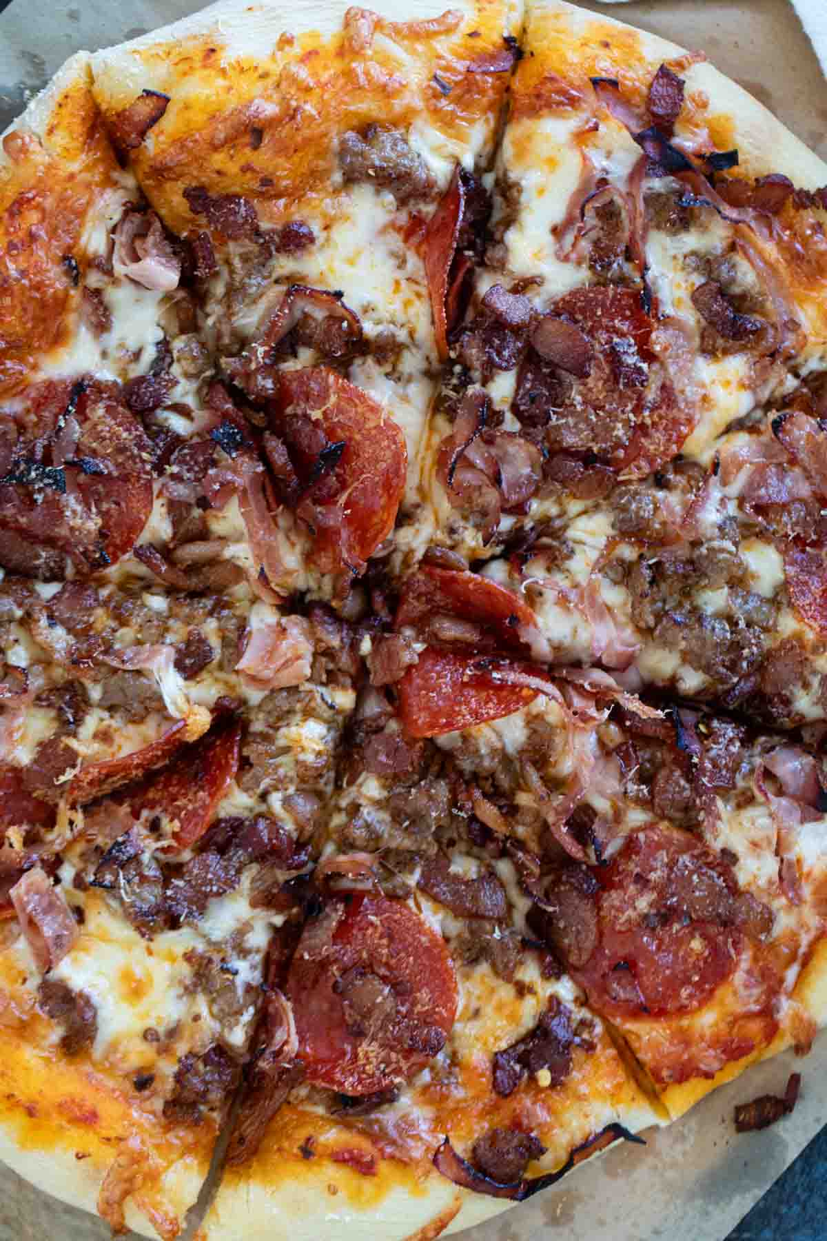 Whole Meat Lover's Pizza cut into slices.