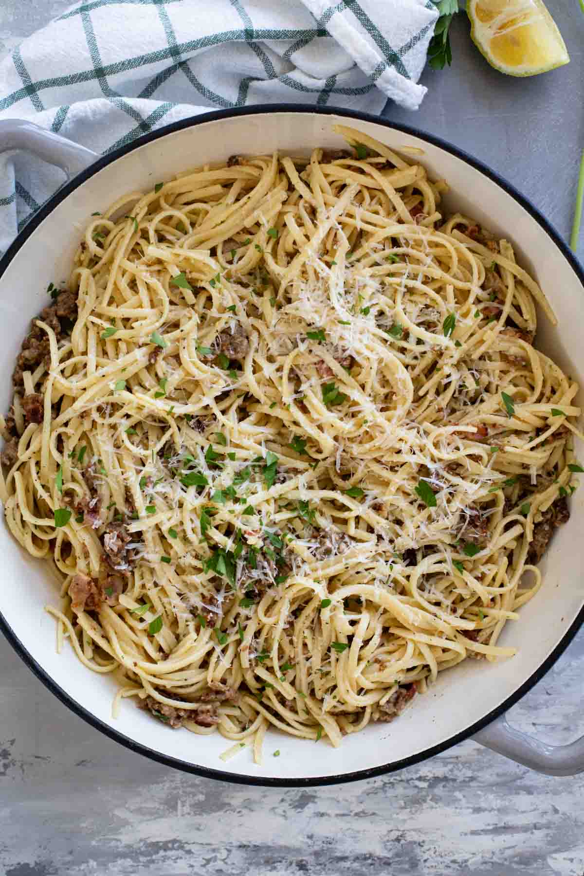 Sausage Carbonara Pasta topped with parmesan cheese in a large skillet.