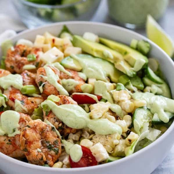 Bowl with grilled Shrimp and Corn Salad with vegetables and avocado ranch dressing.