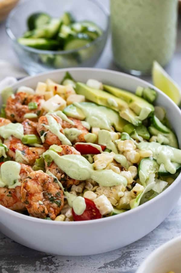 Bowl with grilled Shrimp and Corn Salad with vegetables and avocado ranch dressing.
