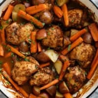 Large skillet with Braised Chicken Thighs with Carrots and Potatoes.