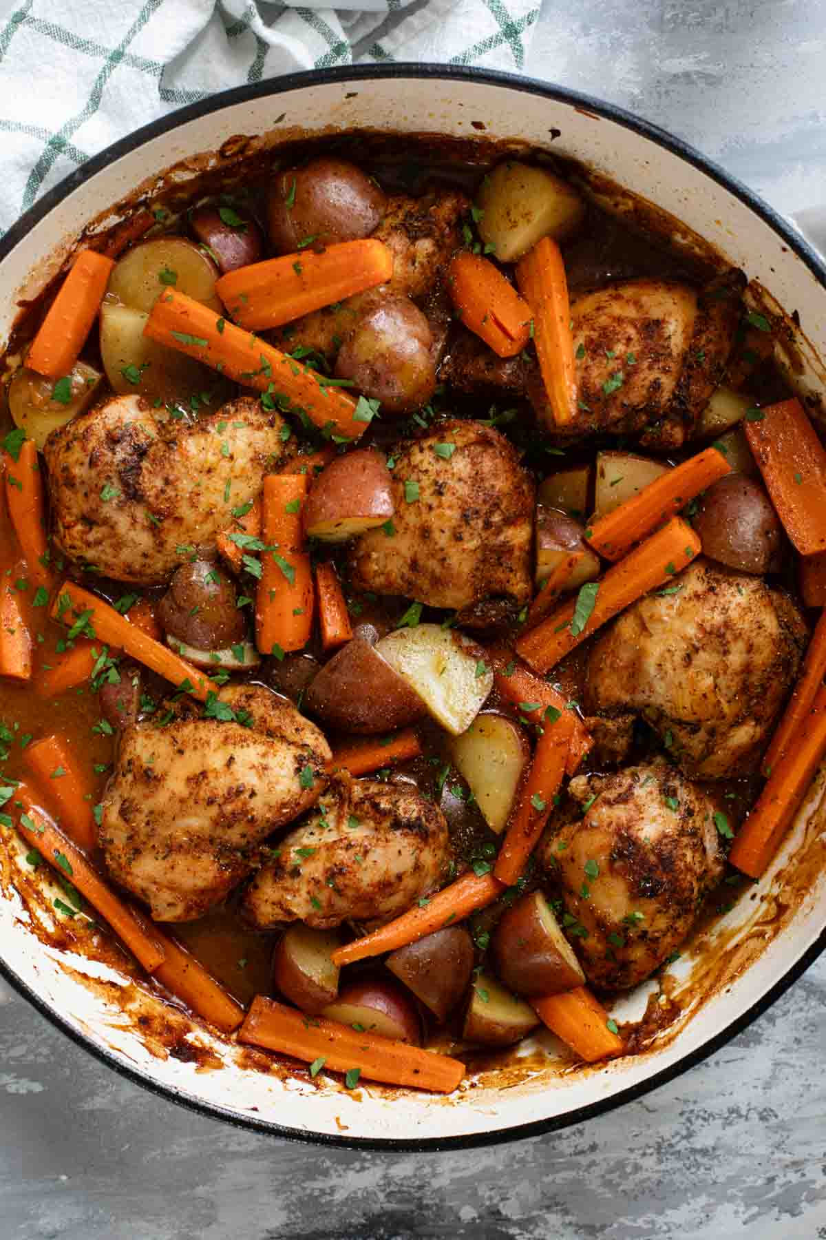 Large skillet with Braised Chicken Thighs with Carrots and Potatoes.
