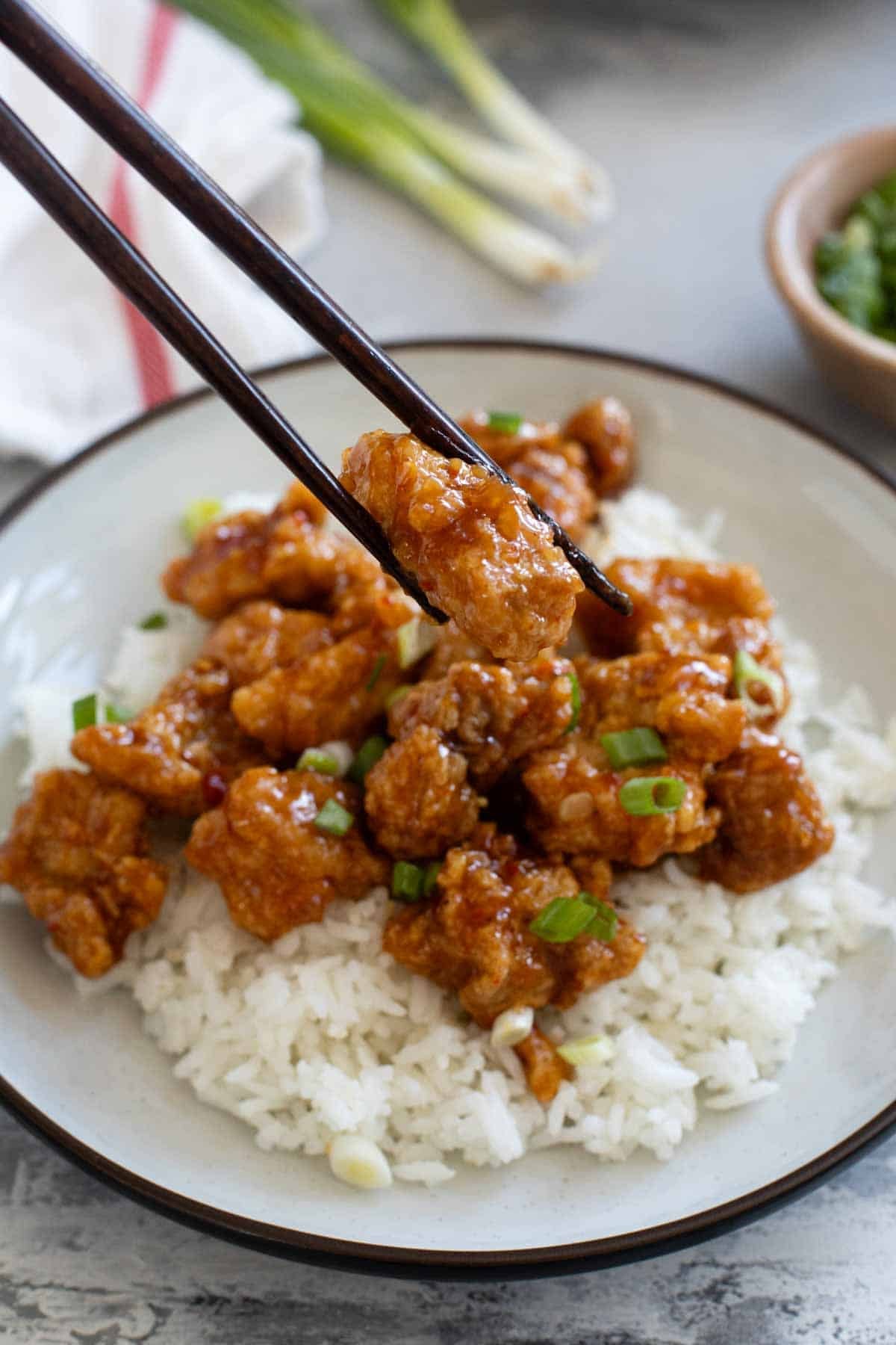 Holding a piece of Chicken Oriental with chopsticks.