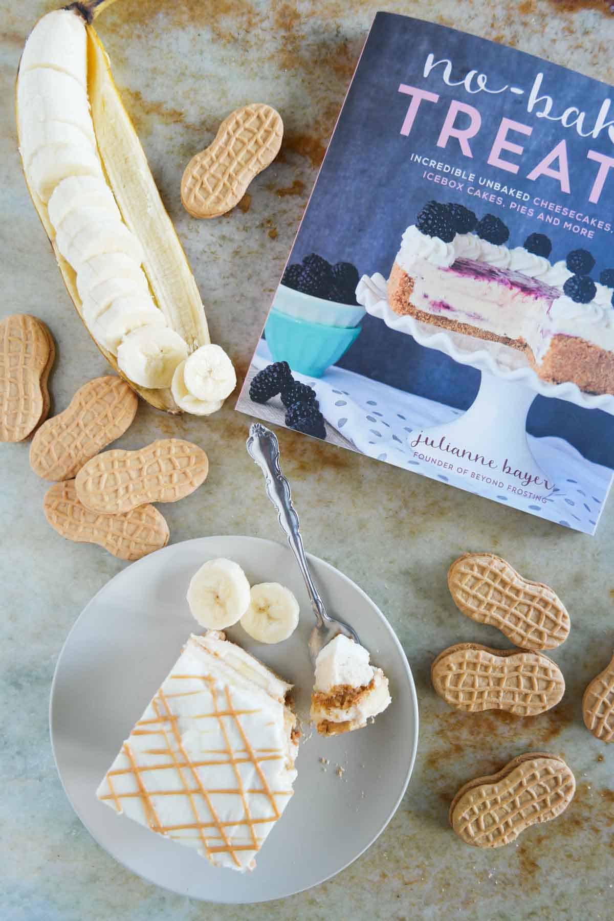 Slice of Peanut Butter Banana Icebox Cake on a plate, with a copy of No-Bake Treats nearby.